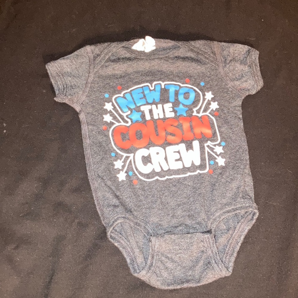 Dark gray one piece that says new to the cousin crew